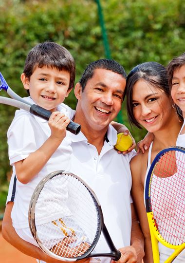 Family holding tennis rackets 