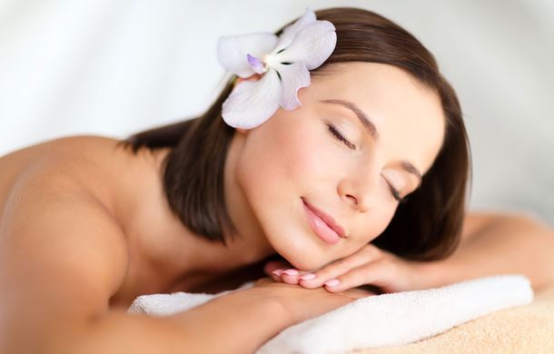 Woman relaxing in spa with flower in hair