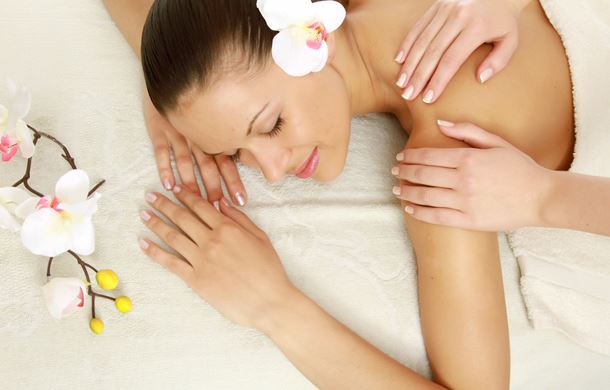 Woman lying on towel receiving massage 