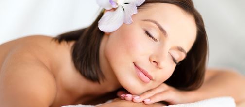 Woman relaxing in spa with flower in hair