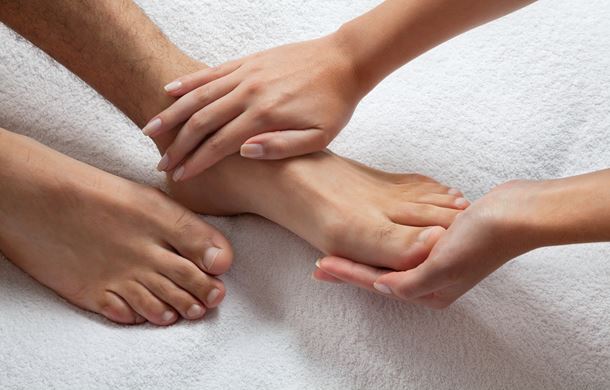 Therapist massaging male foot 