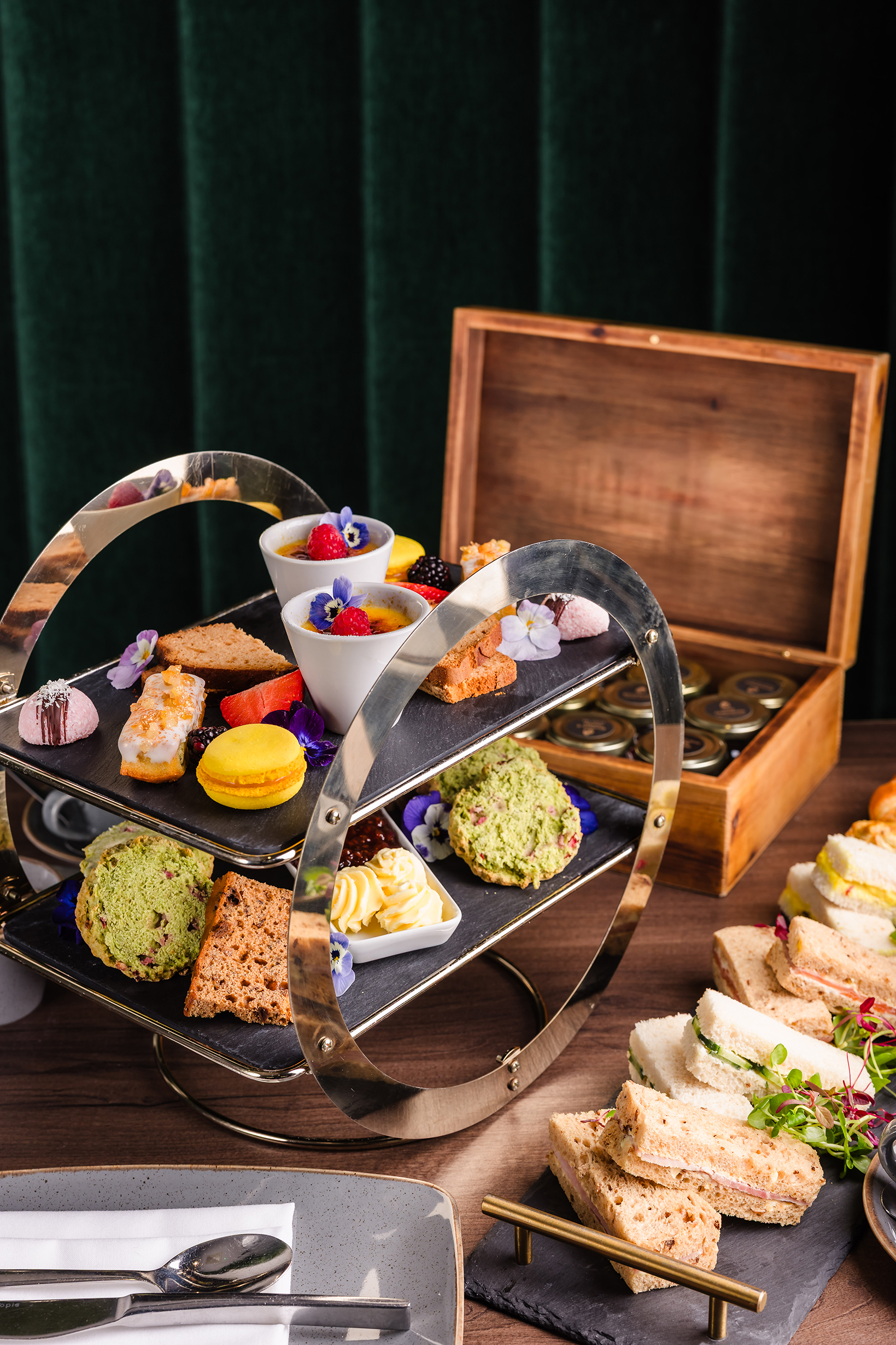 A tiered tray holds assorted pastries, cakes, and desserts—perfect for a classic afternoon tea with finger sandwiches.